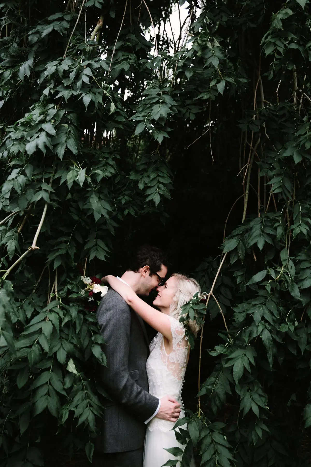 bride and groom hugging in the bushes in Oxfordshire wedding