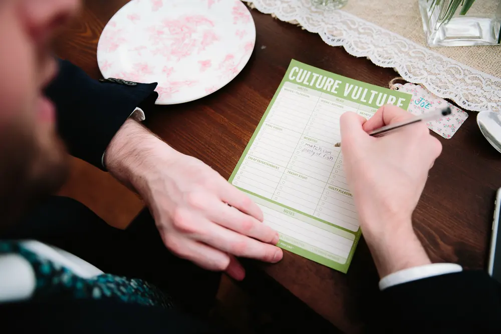 Guest filling in a Culture Vulture activity sheet at a dinner table at the Perch