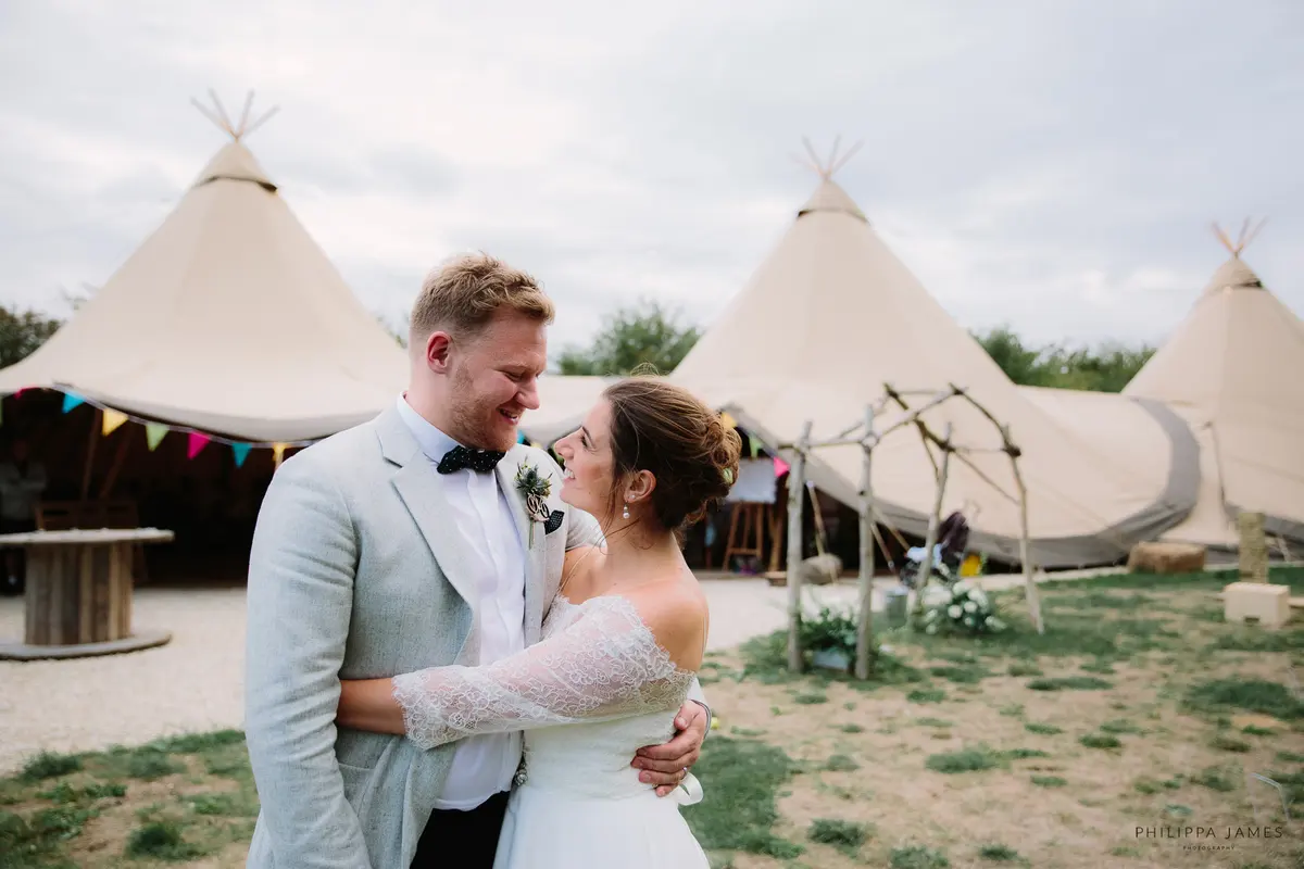 Alternative Wedding Venues in Oxfordshire - Bride and Groom standing in front of tipi