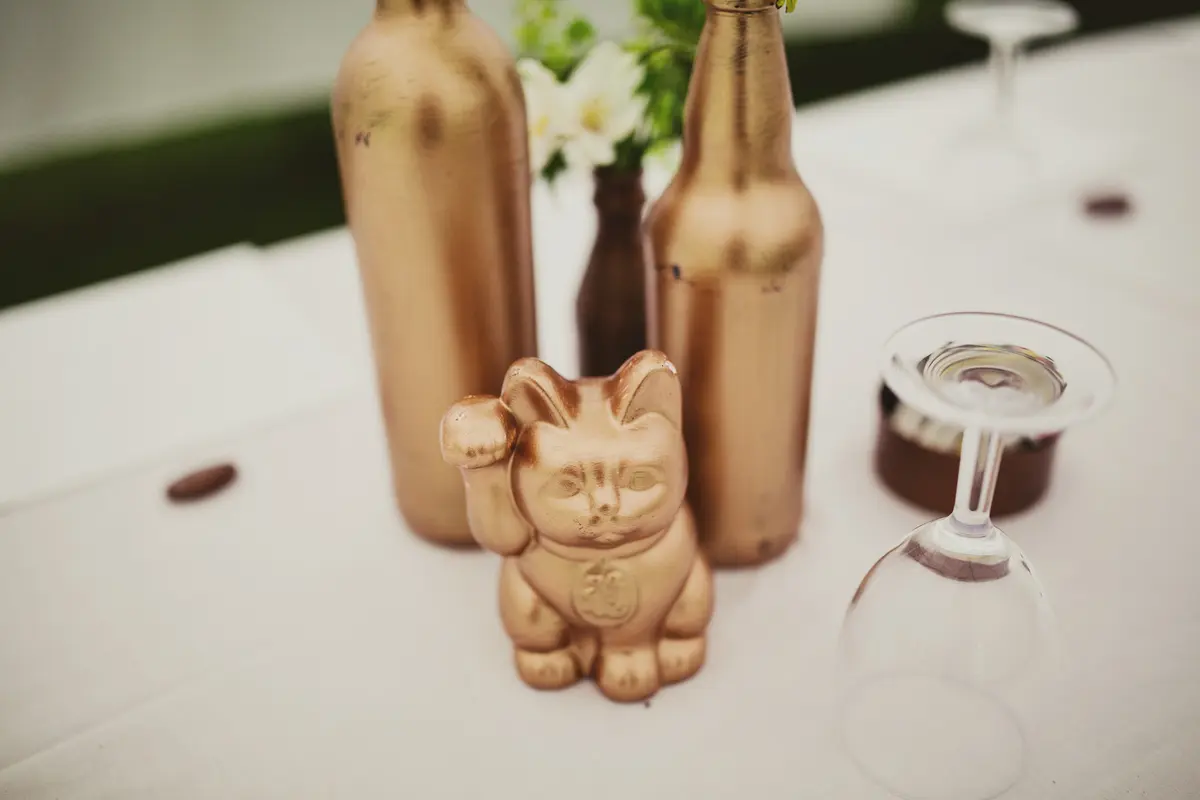 Gold lucky cat figure and gold-painted bottles used as table decorations