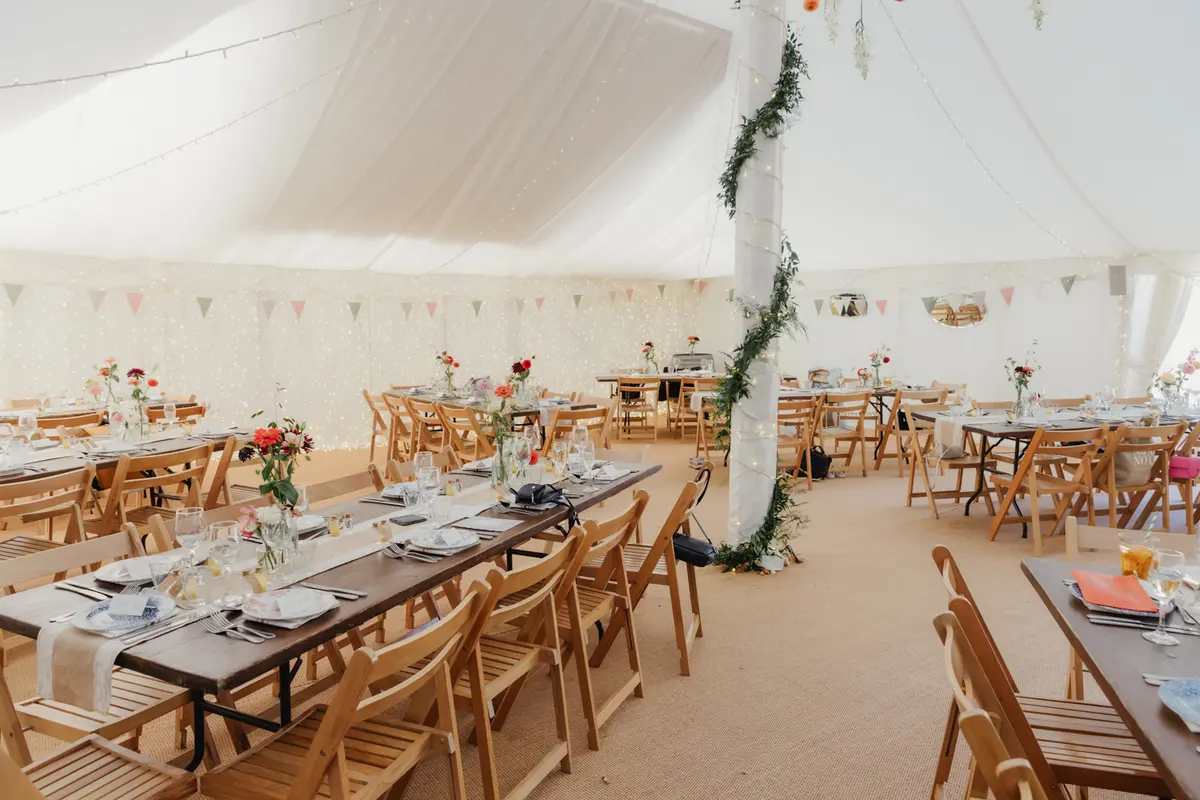 Marquee at the Perch set with flowers, bunting and a foliage-wrapped pole before guests arrive