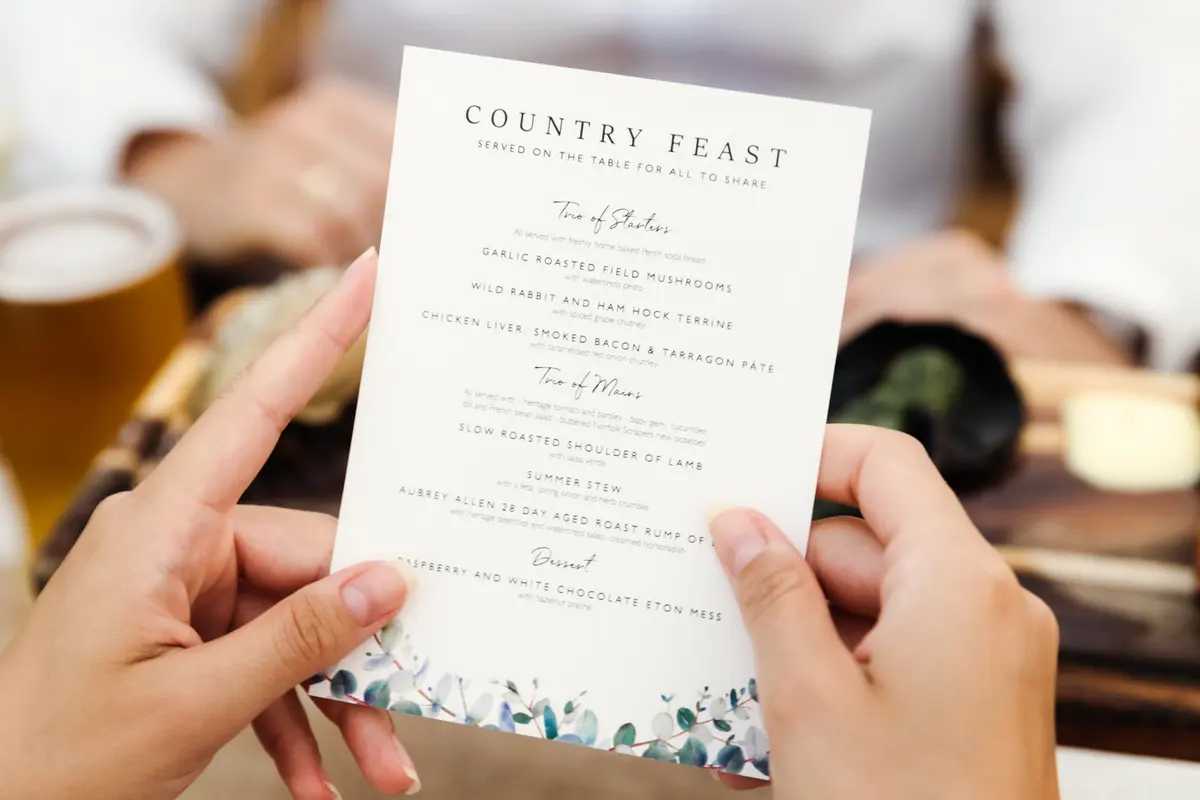 Guest holding a Country Feast menu card at the wedding breakfast at the Perch
