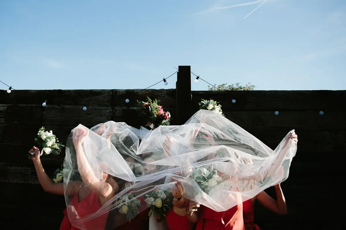 Bridesmaids caught under veil at Manor Farm Barn Wedding venue