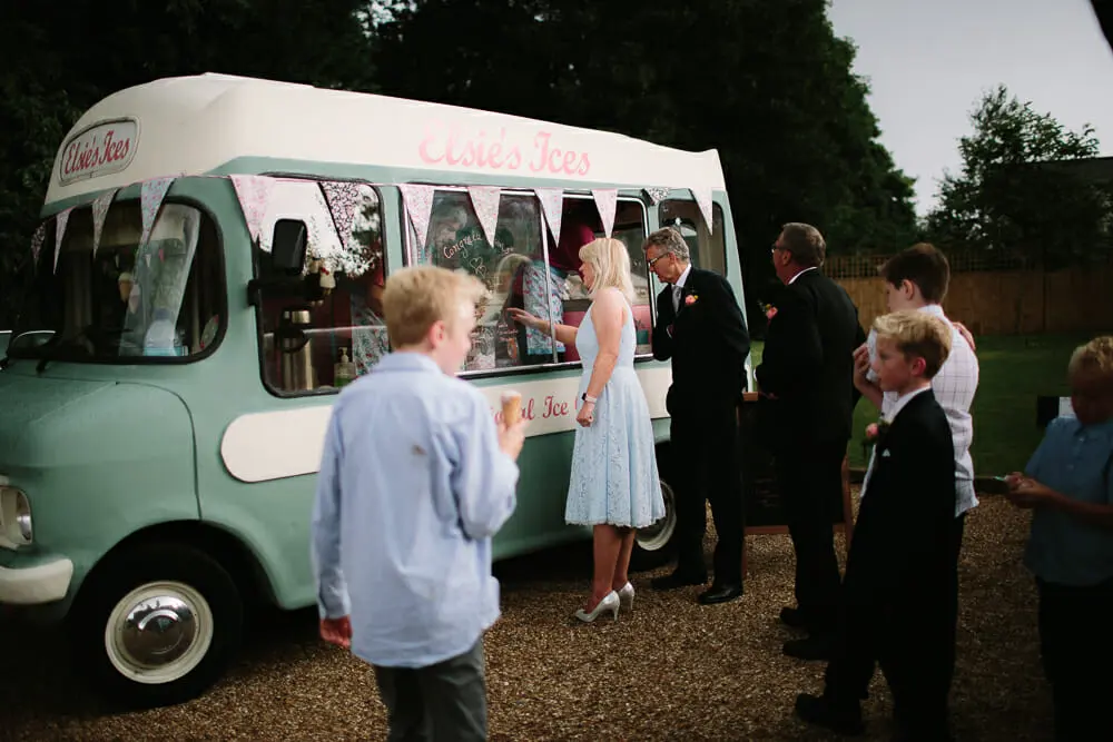 Guests queueing at a vintage mint green ice cream van decorated with bunting