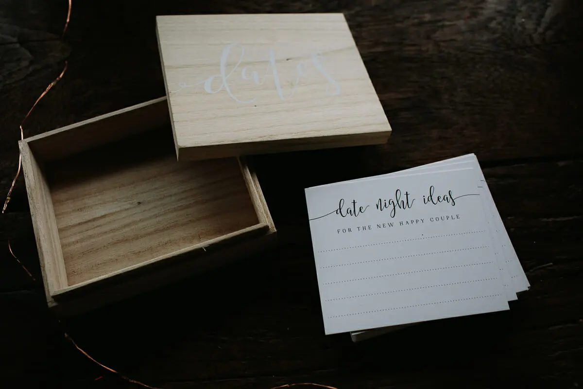 Wooden box labelled dates beside a stack of date night idea cards for the couple