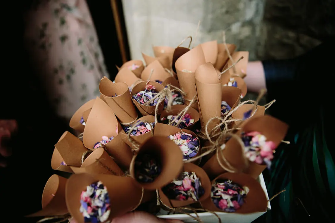 Paper cones filled with pink and purple petal confetti tied with twine