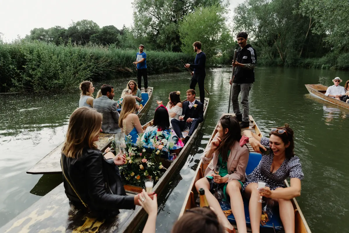 Wedding guests drinking fizz in punts on the River Cherwell, with punters standing at the back