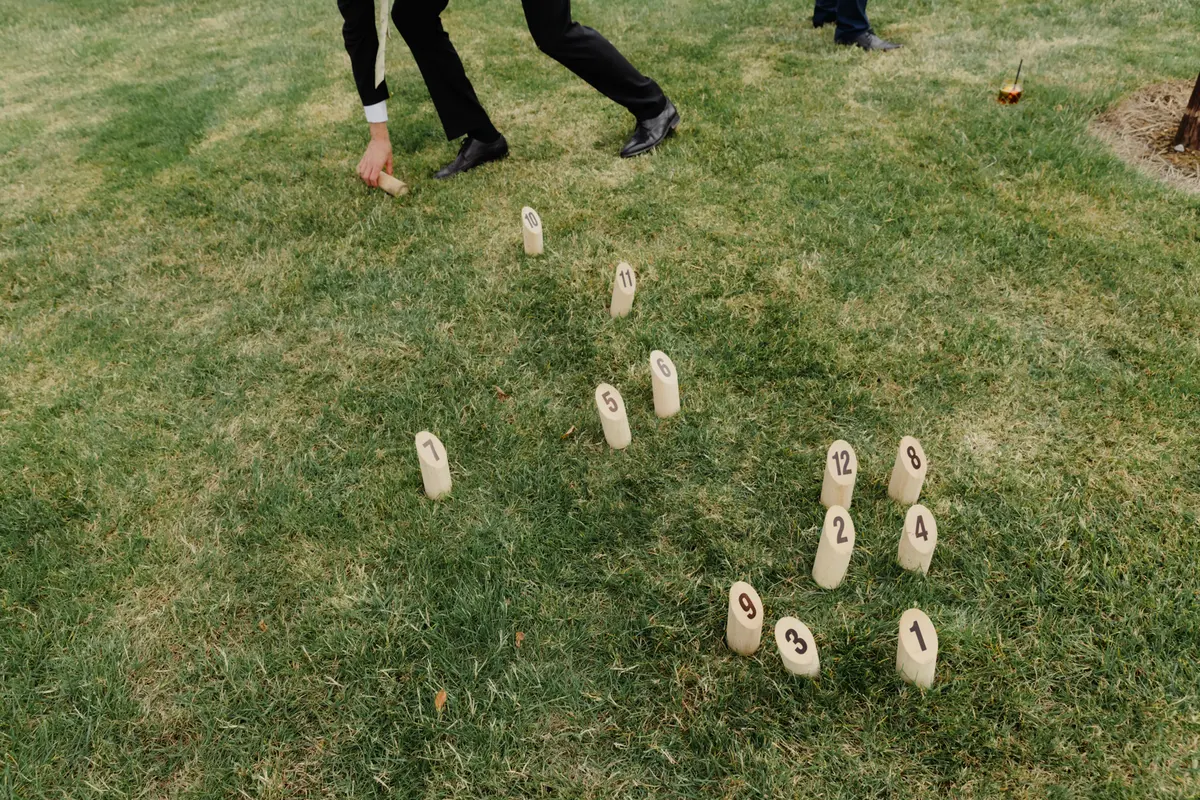Guest throwing a wooden block in a game of molkky on the lawn at Primrose Hill Farm