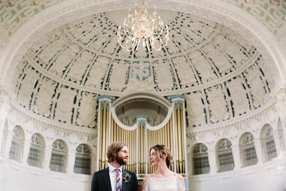 Bride and groom beneath the ornate domed ceiling and organ pipes of Oxford Town Hall